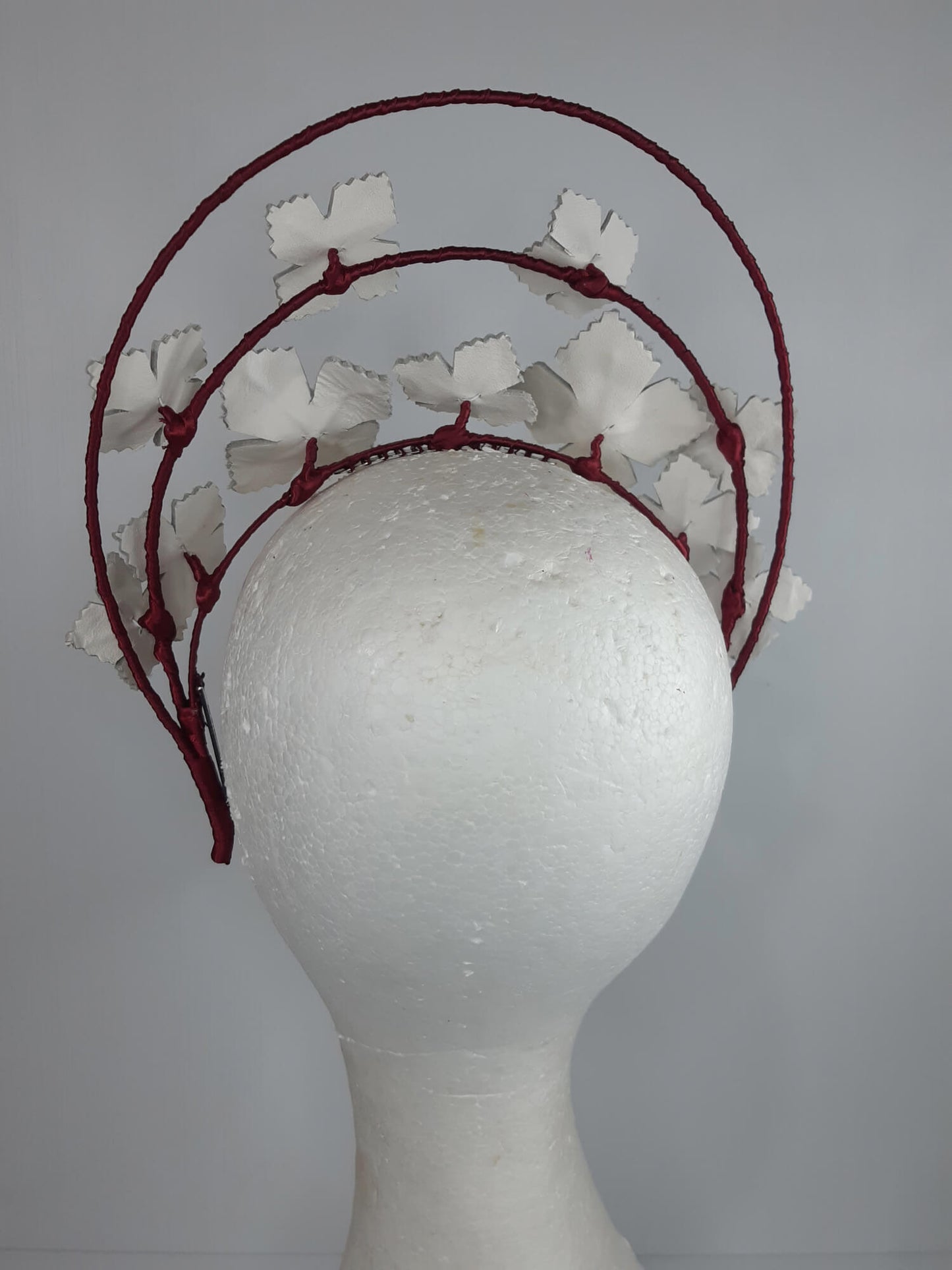 A picture of a Red and White Leather Millinery Halo Crown by Melissa Rath Millinery.