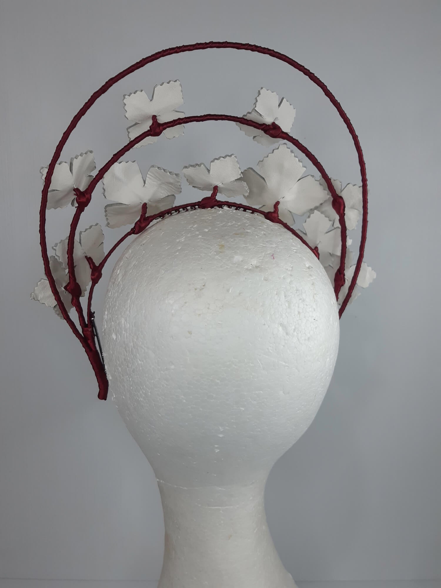 A picture of a Red and White Leather Millinery Halo Crown by Melissa Rath Millinery.