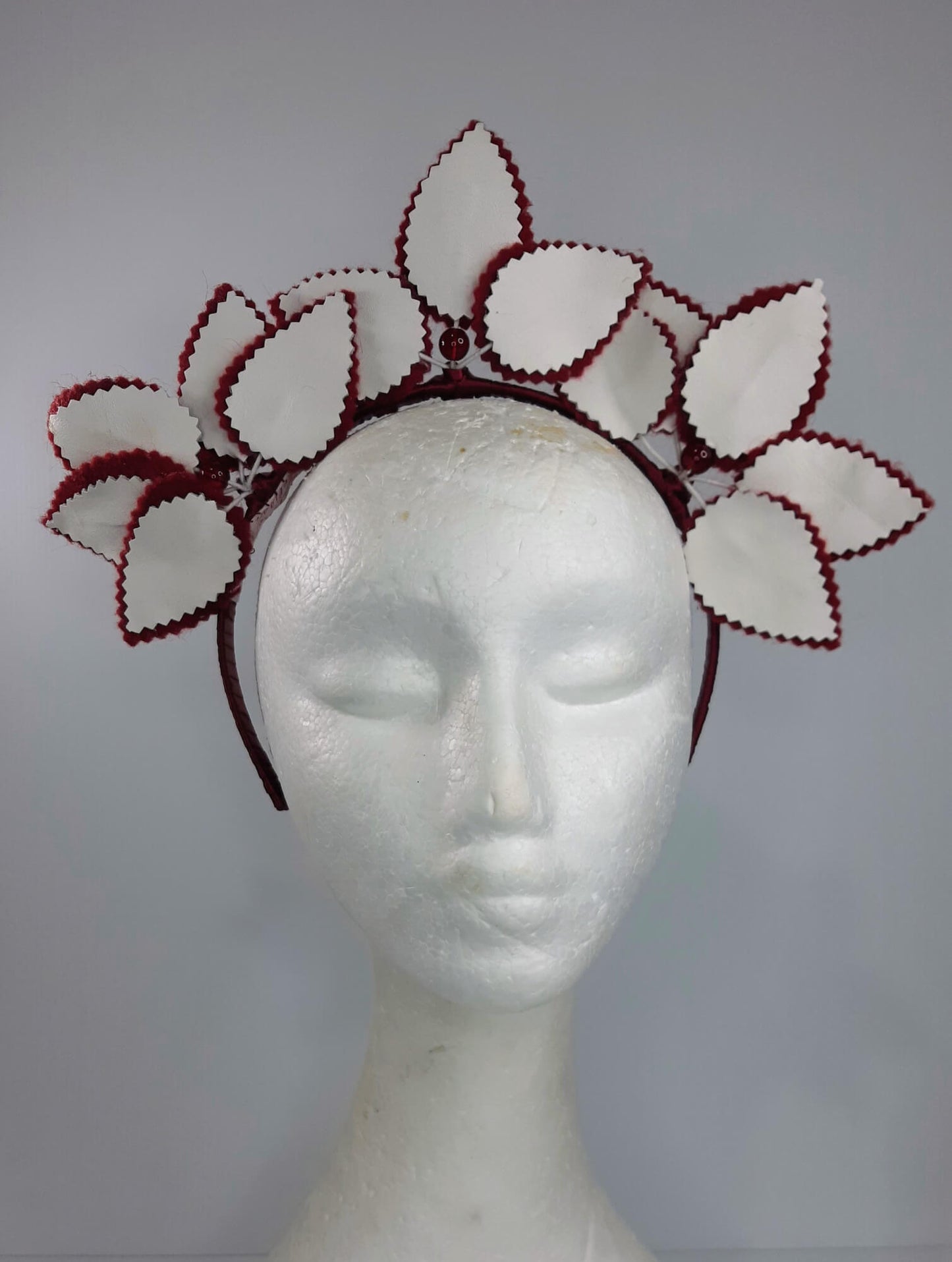 A picture of a red and white leather headband by Melissa  Rath Millinery