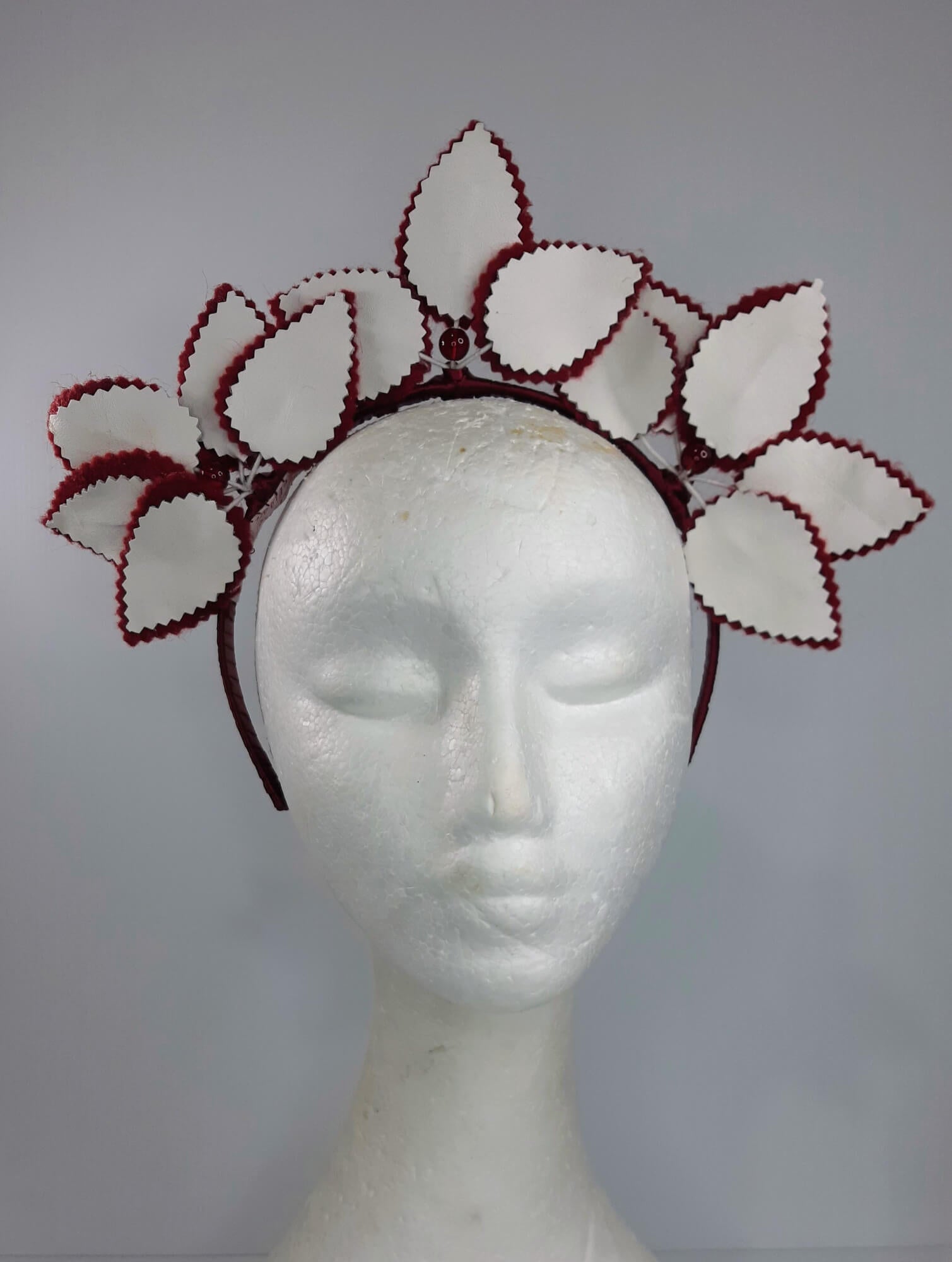 A picture of a red and white leather headband by Melissa  Rath Millinery
