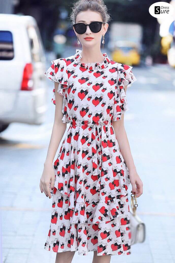  A picture of a woman wearing red hearts print on a dress, which is playful and cute.