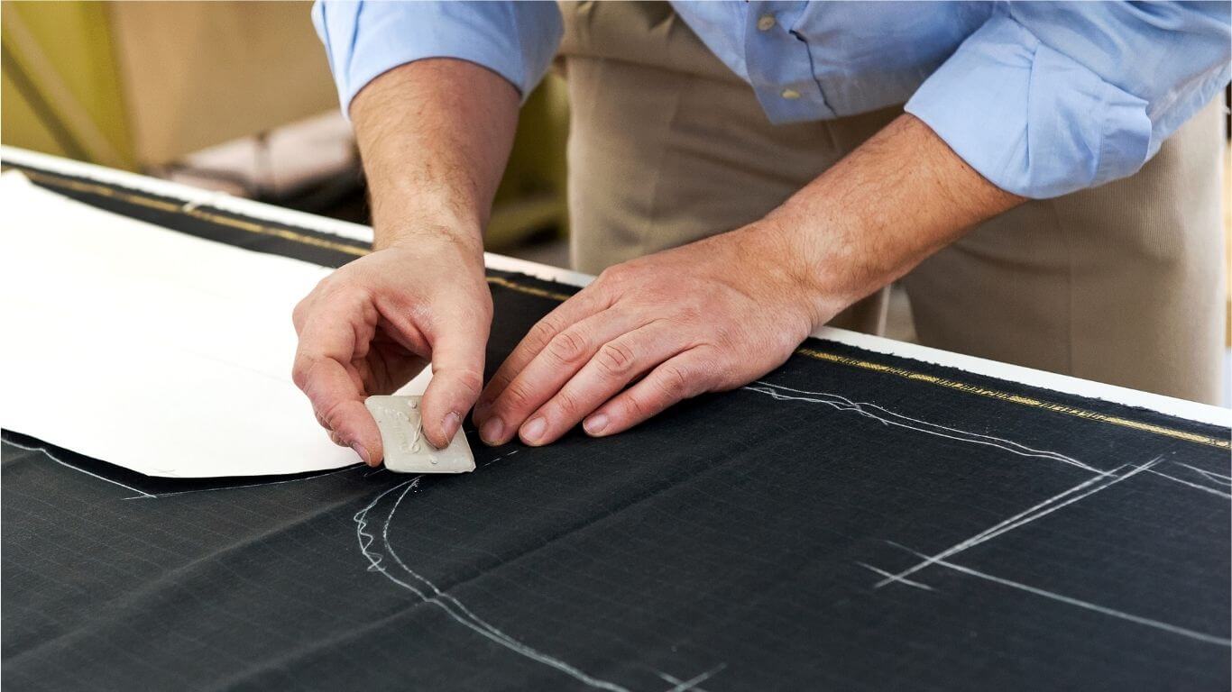 An image of someone drawing on fabric with dressmakers chalk.