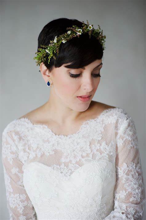 A picture of a lady wearing a millinery crown with short hair.