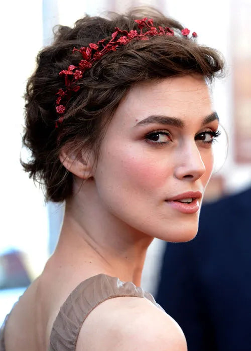 A picture of a lady wearing a millinery crown with short hair.