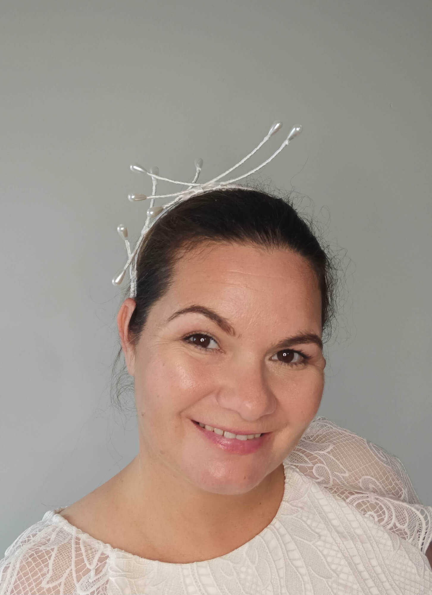 A picture of an Asymmetrical White Beaded Millinery Headband by Melissa Rath Millinery.