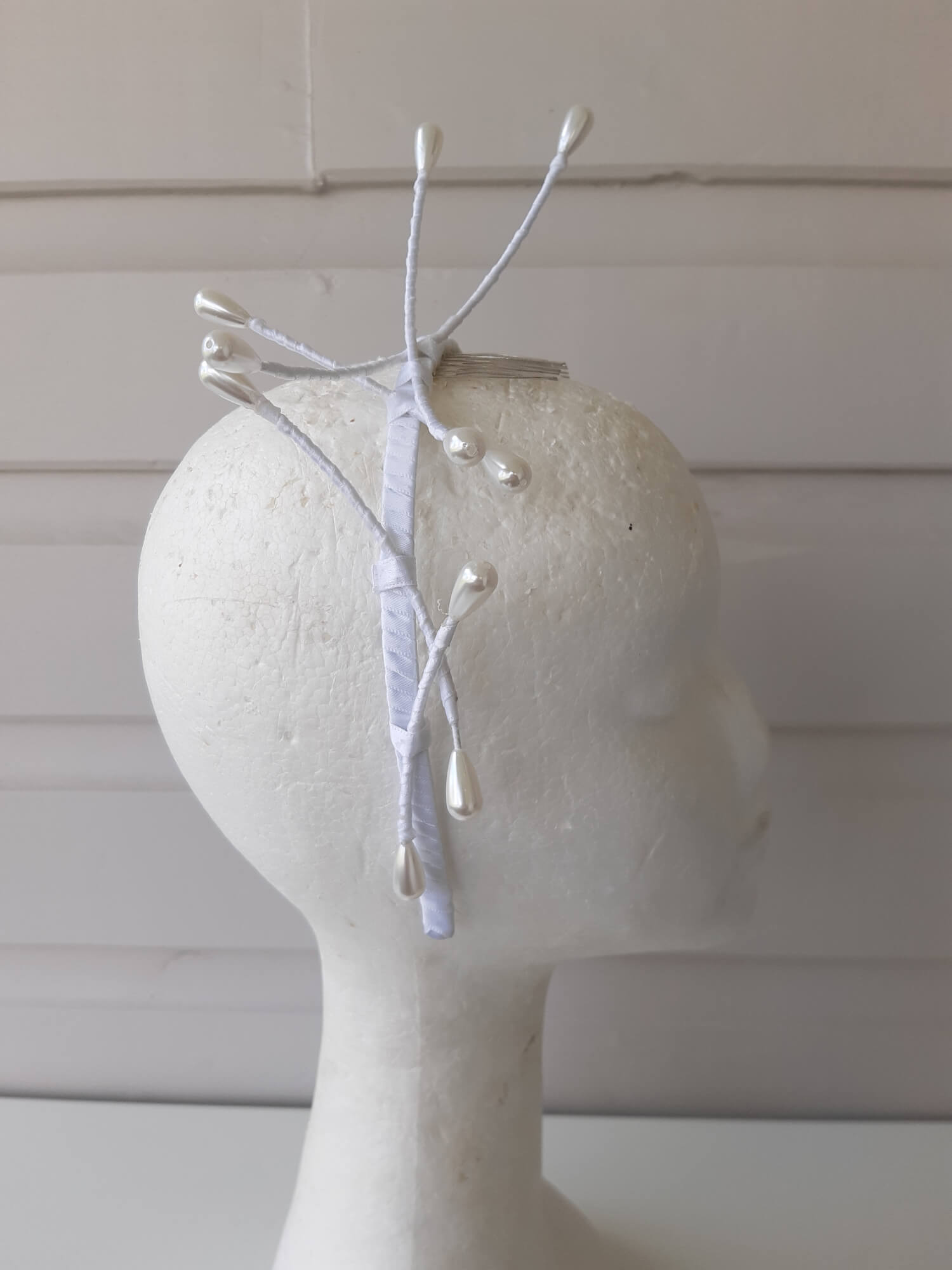 A picture of an Asymmetrical White Beaded Millinery Headband by Melissa Rath Millinery.