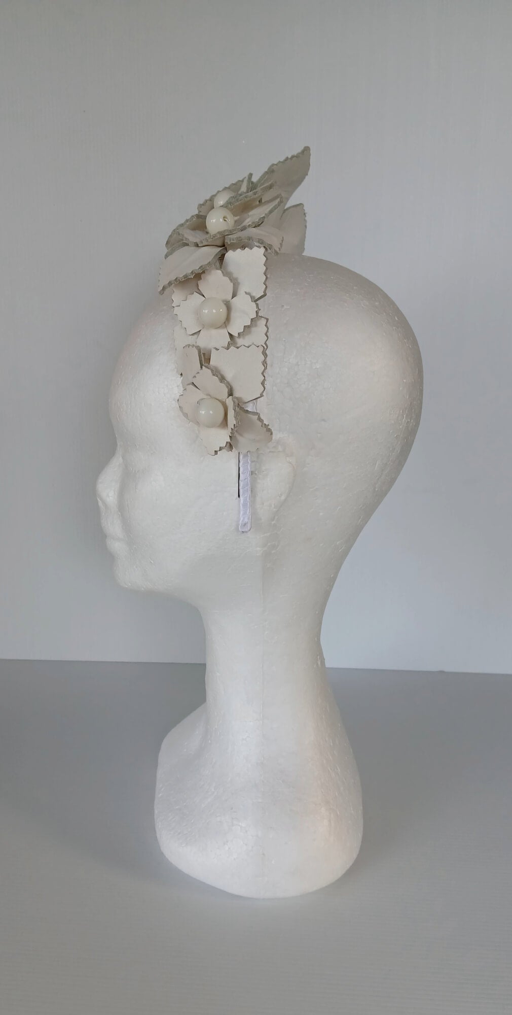 A picture of a white leather millinery crown by Melissa Rath Millinery.