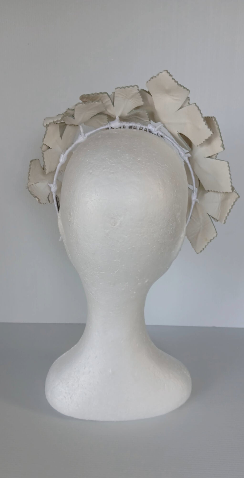 A picture of a white leather millinery crown by Melissa Rath Millinery.