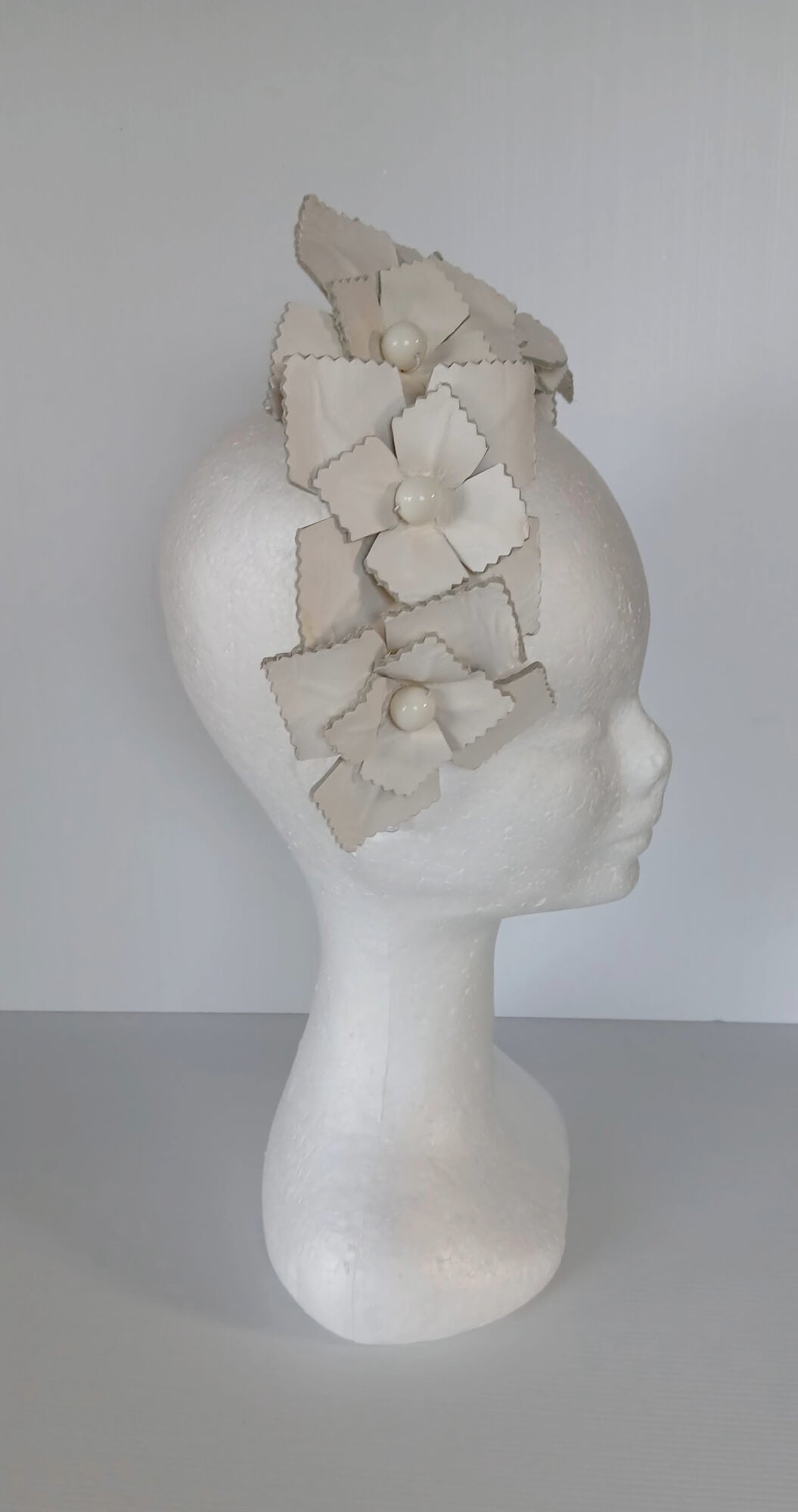 A picture of a white leather millinery crown by Melissa Rath Millinery.