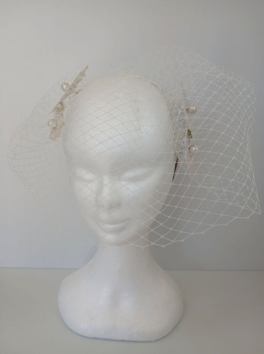 A picture of a White Pleather Veiled Millinery Headband by Melissa Rath Millinery.