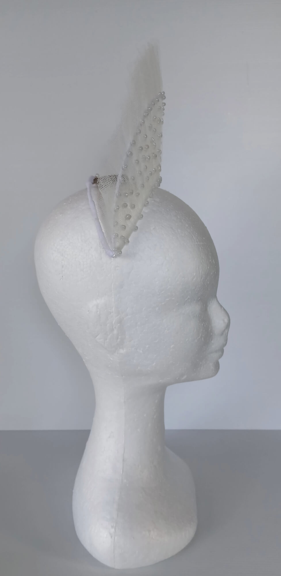 A picture of a White Beaded Tulle Millinery Crown by Melissa Rath Millinery.