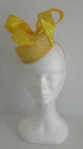 A picture of a yellow sinamay fascinator with a wired bow by Melissa Rath Millinery.