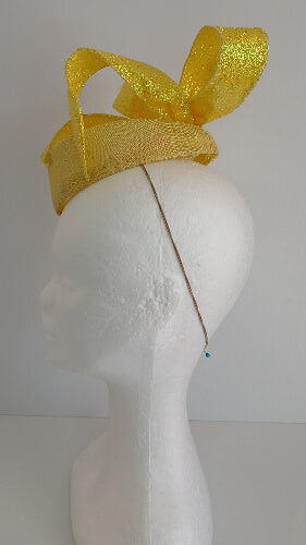 A picture of a yellow sinamay fascinator with a wired bow by Melissa Rath Millinery.