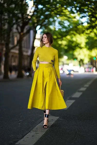 A picture of a woman wearing an outfit in a yellow monochromatic colour scheme.