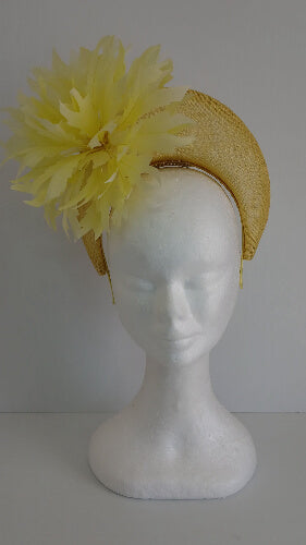 A picture of the yellow sinamay blocked crown with feather flower by Melissa Rath Millinery.