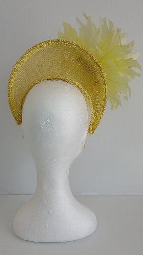 A picture of the yellow sinamay blocked crown with feather flower by Melissa Rath Millinery.