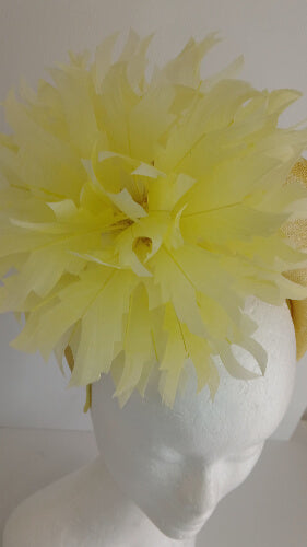 A picture of the yellow sinamay blocked crown with feather flower by Melissa Rath Millinery.