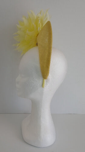 A picture of the yellow sinamay blocked crown with feather flower by Melissa Rath Millinery.