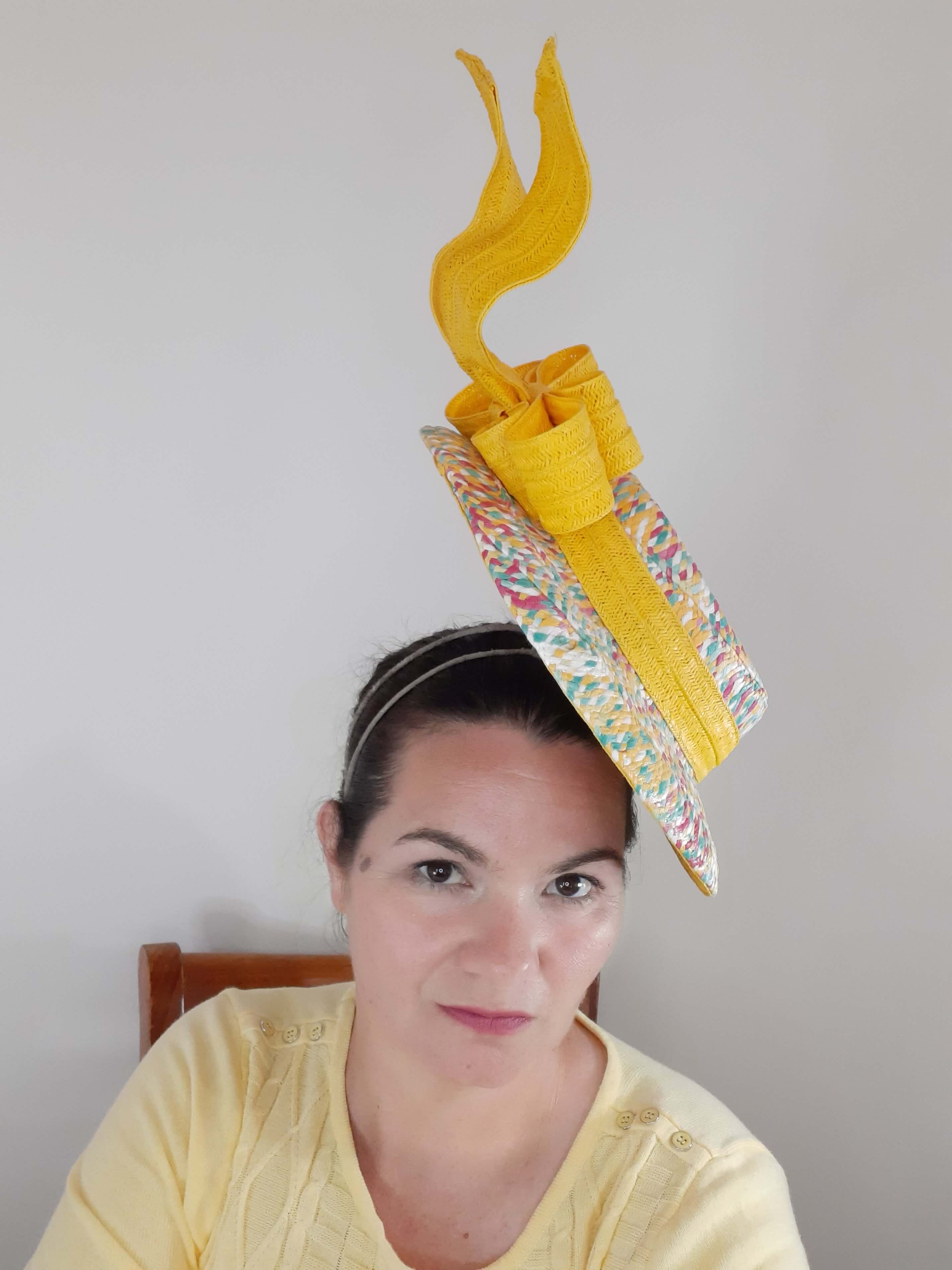 A picture of a floating boater hat in yellow by Melissa Rath Millinery.